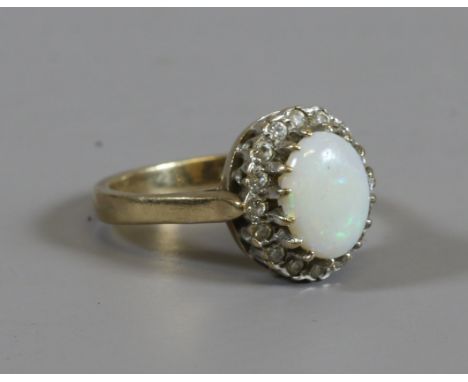 A 9ct gold opal dress ring set with a border of white paste, assayed Birmingham 1988, size K.