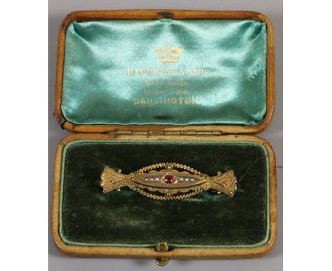 A cased Edwardian 9ct gold cannetille work brooch set with a ruby and seed pearls, assayed Chester 1903, gross weight 3.2 gra