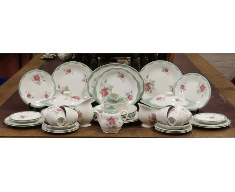 A Royal Staffordshire pottery dinner and tea service by Clarice Cliff decorated with roses under teal edged borders, approxim