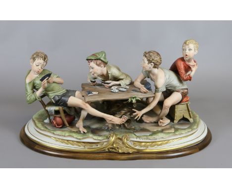 A large Capodimonte coloured bisque figure group 'the card cheat' modelled in the form of three boys playing cards, signed Me
