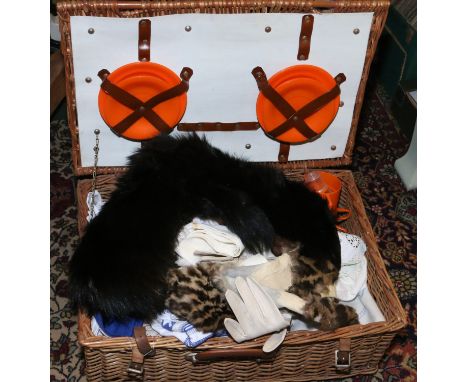 A vintage wicker picnic hamper and contetns of mixed linens, fur stoles etc.