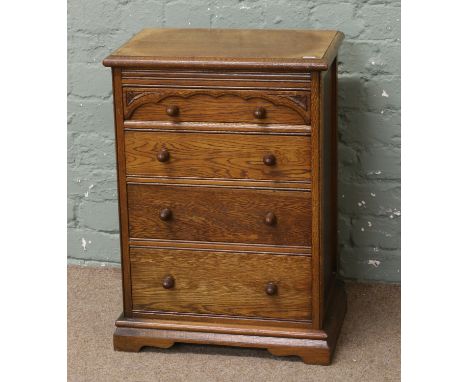 A 1930s oak apprentice chest of four drawers with turned acorn handles and raised on bracket feet.