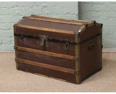 A vintage American wood bound dome top travel trunk.