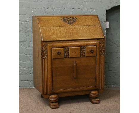A 1940s light oak carved bureau.