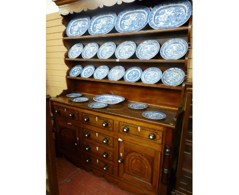 A mid 19th Century Anglesey oak Welsh dresser, the three shelf rack having a shaped hood and sides (re-boarded back) to a bas