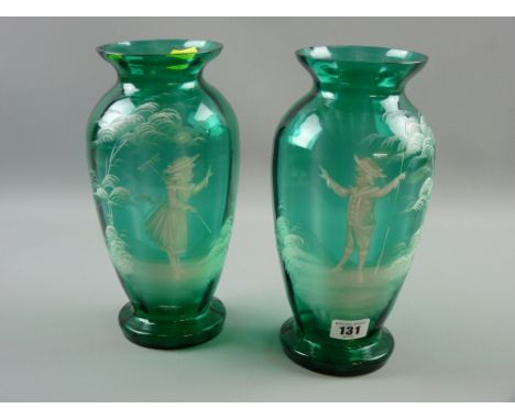 A pair of Mary Gregory green glass vases, enamel painted with opposing figures of a young boy and young girl, 26 cms high (so