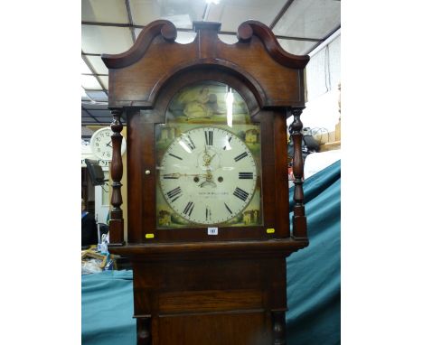 An oak and mahogany 19th Century longcase clock having a domed and scrolled hood with turned columns and with an eight day mo