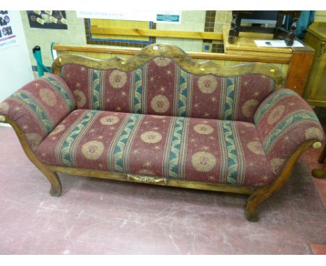 A double ended early 20th Century sofa having a shaped rail back with gently scrolled arms and splayed supports