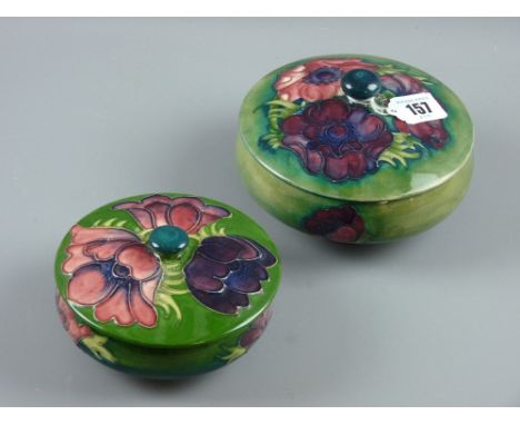 Two Moorcroft pottery 'Anemone' powder pot and covers, green/blue ground bodies, 14 cms diameter the largest with impressed f