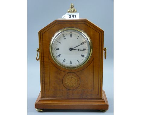 A satin walnut Sheraton style inlaid mantel clock with circular dial having Roman numerals, gilt brass top finial, side carry