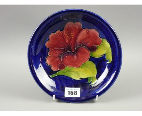A Moorcroft pottery 'Hibiscus' plate, 18.5 cms diameter, painted and impressed factory marks to the base (light crazing, firi