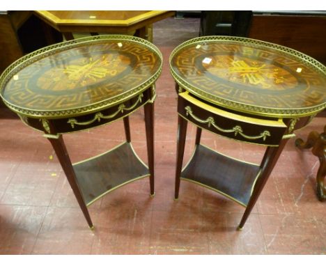 A pair of reproduction Empire style oval topped side tables with pierced brass galleries, multi-wood inlaid and painted tops,