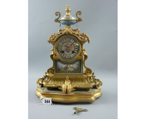 A French gilt metal clock with painted porcelain dial and inset lower panel, the top surmounted with a gilt metal and porcela