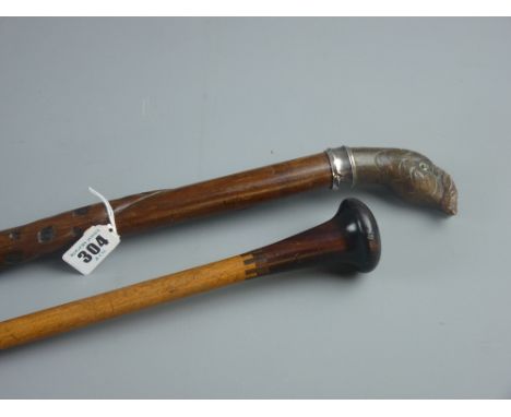 A carved walking cane with entwined snake stamped 800 metal collar and carved wooden turkey's head handle with inset glass ey