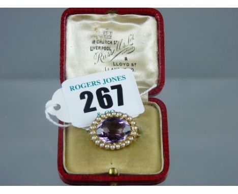 A fifteen carat gold oval amethyst and seed pearl brooch, 3.5 grms in original Russell Ltd, Liverpool & Llandudno box