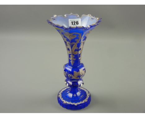 A late 19th Century Bohemian blue glass vase, facet cut bulbous column and base with white painted enamel and gilt decoration