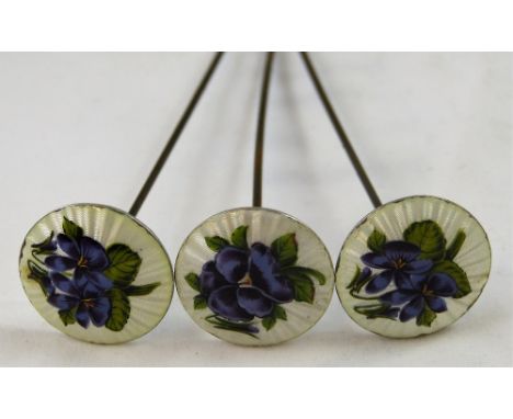 An Edwardian silver and enamel set of three hat pins, by L. Emmanuel, Birmingham 1908, with white guilloche enamel and purple