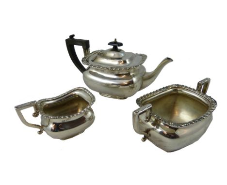 An Edwardian silver three piece tea service, Chester 1904, of rectangular form with gadrooned borders, ebonised handle and fi