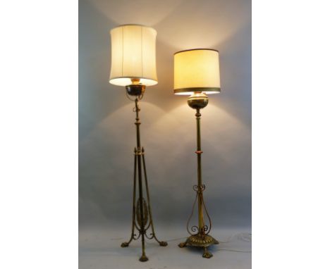 An early 20th century Art Nouveau brass standard lamp, the central tubular column with laurel mounts and three strapwork supp