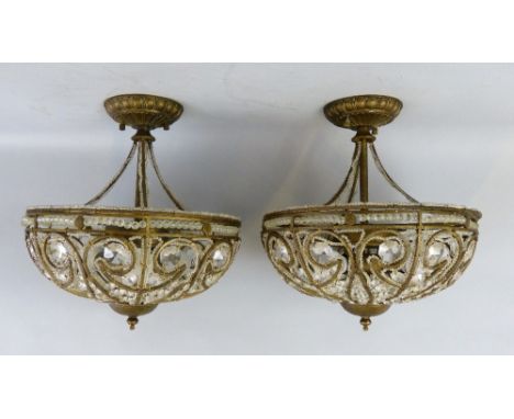 A pair of Italian brassed iron framed ceiling lights, each of semi-circular form with open scrolling framework draped with cl