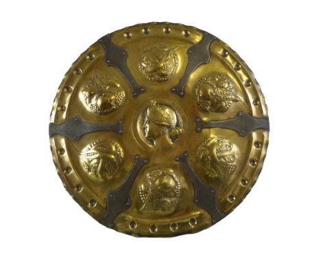 An Arts and Crafts brass wall plaque, of circular form with central embossed portrait of Psyche surrounded by alternate embos