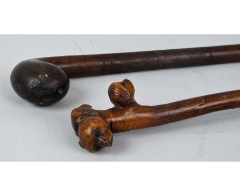 An early 20th century walking stick, made from a single briar, the handle carved from the root as three dog's heads looking i