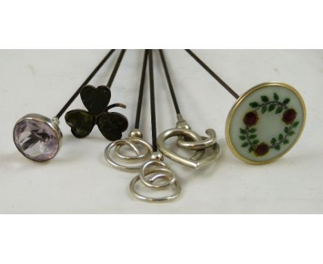 An Edwardian silver pair of hat pins, Birmingham 1906, of scroll form, a coromandel marble and silver shamrock hat pin, a sil