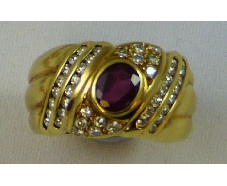 An 18ct gold ruby and diamond dress ring, signed REX, the collet set mixed cut stone within a brilliant cut diamond set frame