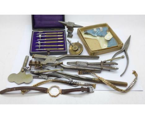 A collection of watch making tools and a miniature anvil stamped France 