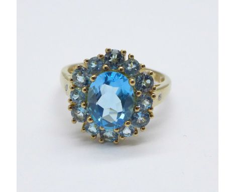 A 9ct gold and blue stone cluster ring with a small diamond set in each shoulder, 3.9g, P 