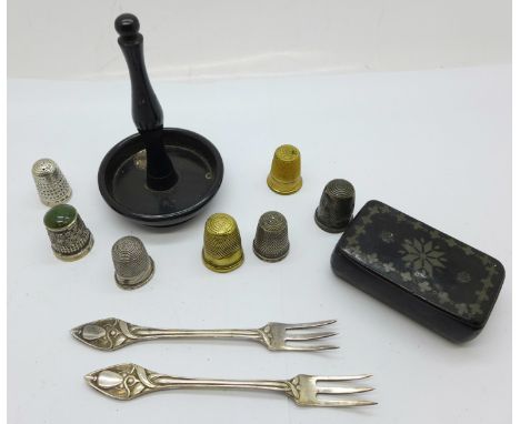 Four silver thimbles, three other thimbles, a ring stand, a snuff box and a pair of plated Art Nouveau style pickle forks, a/