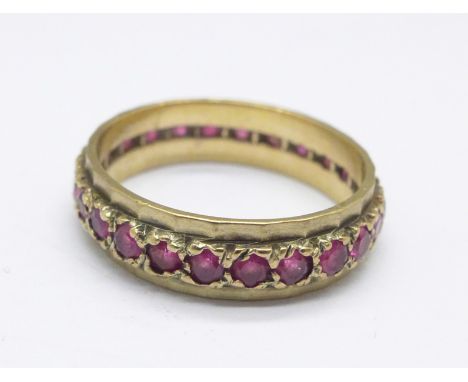 A yellow metal and ruby eternity ring, 2.5g, L 