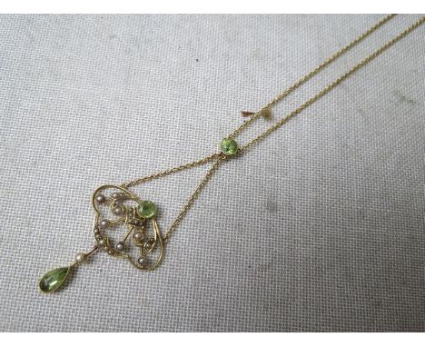 A 15ct gold art nouveau pendant set with a peridot and split seed pearls on a 15ct gold chain necklace