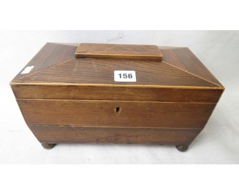 A Regency rosewood sarcophagus shaped tea caddy with inlaid stringing, gilt brass ring handles and ball feet, fitted interior