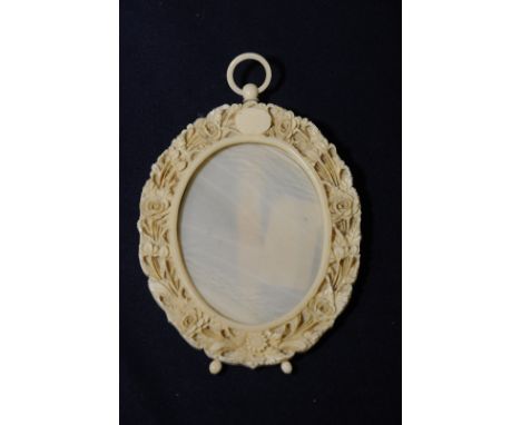 Early 20th C carved ivory circular picture frame with easel back and hanging loop, the border with carved floral detail (9cm 