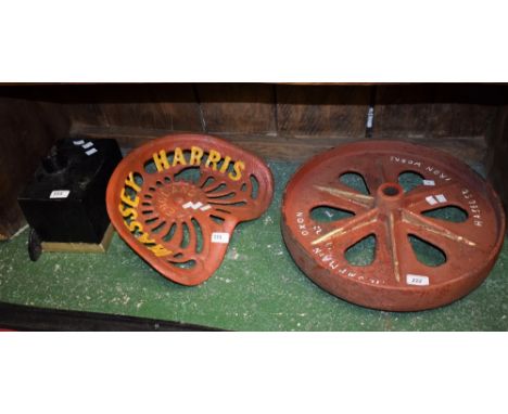 A Massey Harris tractor seat; a Victorian drain hopper; an industrial fly wheel