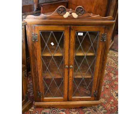 An Old Charm oak wall mounted corner cabinet with two lead glazed doors, model 1914.