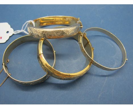 A Chester Hallmarked Silver Gilt Bangle, leaf scroll engraved, hinged to snap clasp; together with three further bangles incl