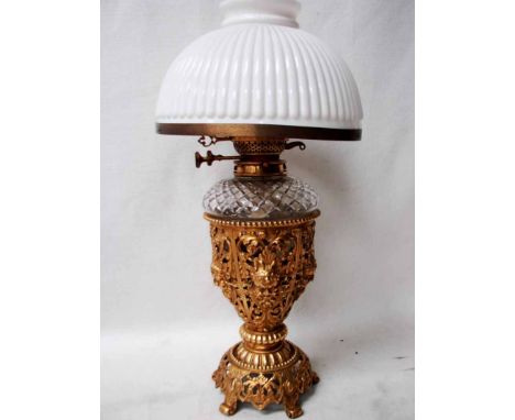 A Victorian Oil Lamp, the gilt pierced metal base of chalice form decorated with six panels of acanthus leaves and Green Man 