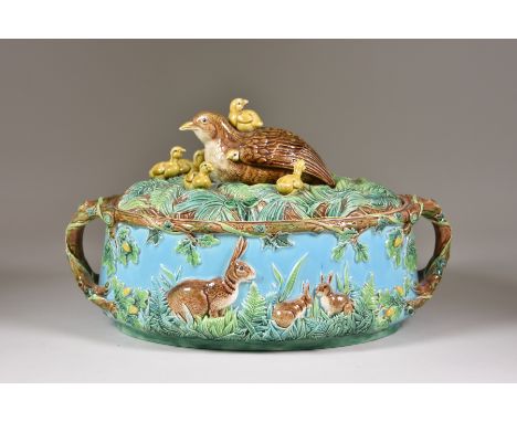 A George Jones Majolica Game Pie Dish and Cover, Circa 1873, of oval form moulded with a frieze of rabbits seated among grass