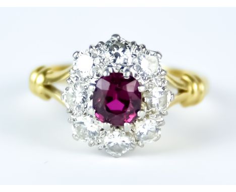 A 18ct Gold Diamond and Ruby Flower Head Ring, Modern,set with a centre ruby,  approximately .75ct surrounded by eight brilli