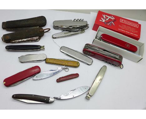 A collection of pocket knives including one Victorinox, two other multi-tool, etc. 