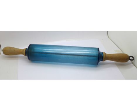 A glass rolling pin with wooden handles 