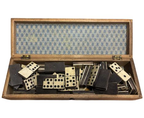 A set of vintage wood and bone dominoes, held in accompanying wooden box. 