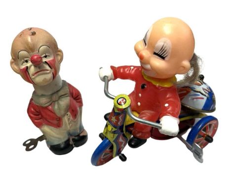 A pair of vintage tin and plastic mechanical toys formed as a clown on a tricycle (Korea) and a grumpy clown (Japan)