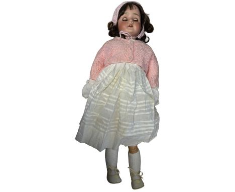 A large Schoenau &amp; Hoffmeister bisque head doll with composition limbs, with brown eyes and brown hair in knitted cardiga