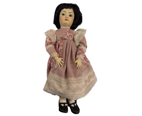A bisque head Simon and Halbig oriental-style doll in pink floral dress. Dark brown eyes and black hair. Marked to rear of he