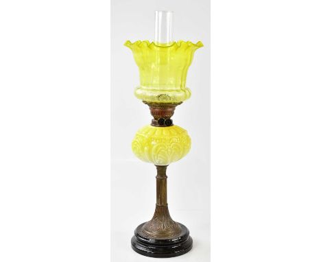 A Victorian oil lamp, the vaseline and clear glass shade with wavy rim and etched floral decoration above the yellow glass re