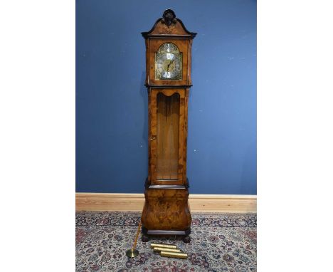 A reproduction inlaid walnut longcase clock with open shell pediment above the brass base, applied chapter ring bearing Roman