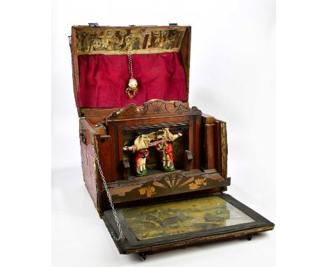 A dome top travelling trunk, the hinged cover enclosing a musical theatre.Condition Report: The trunk is in need of attention